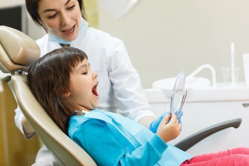 young girl smiling in dental mirror in duncan