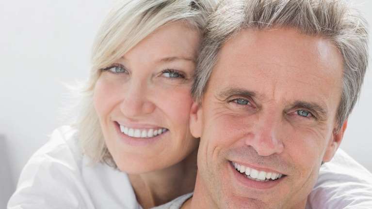 happy couple poses for a photo, both smiling widely, reflecting their satisfaction and connection.
