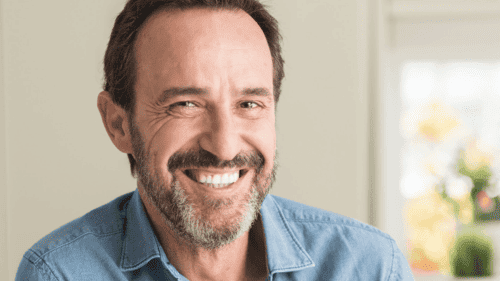 A man smiling brightly, showcasing healthy teeth after successful dental implant care in Duncan, BC.