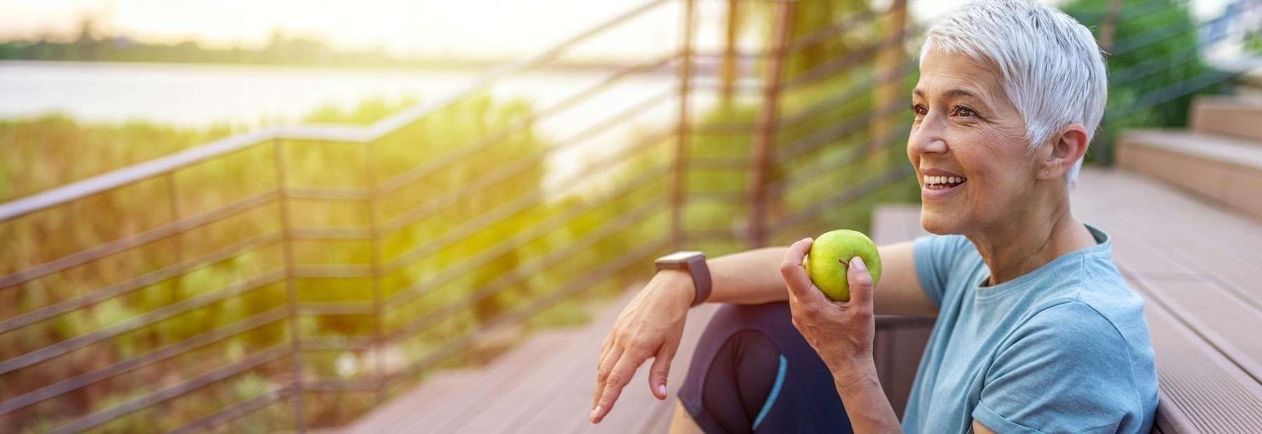 woman eating an apple after getting dental implants in duncan